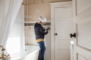 factors that affect the cost of bathroom remodels DIY remodeler installing shower tiles custom built michigan