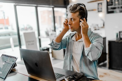 Man on the computer with headphones on - keywords for affiliates sites