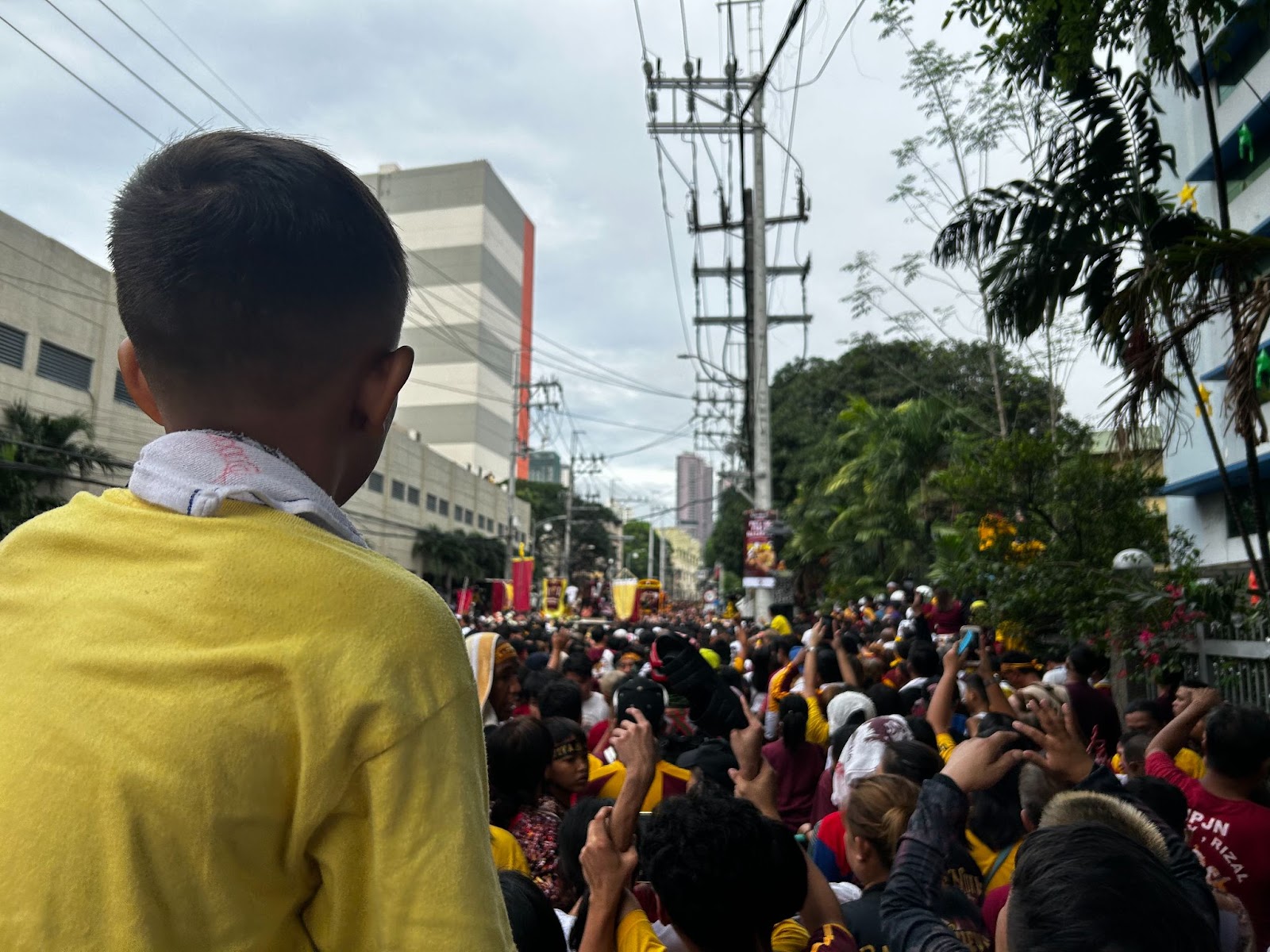 A child joins the procession of the Black Nazarene while being carried on top of his father’s shoulders.
