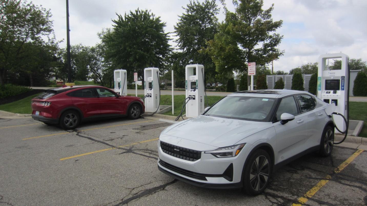 A white car parked at a charging station

Description automatically generated