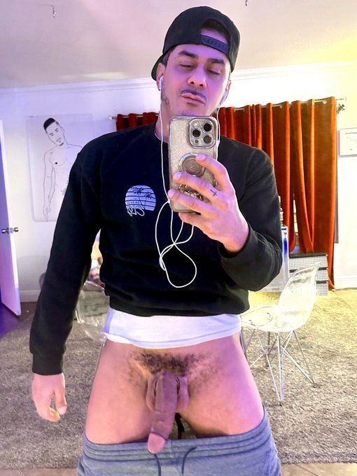 Cesar Xes with his grey sweatpants pulled down to reveal his half erect cut penis