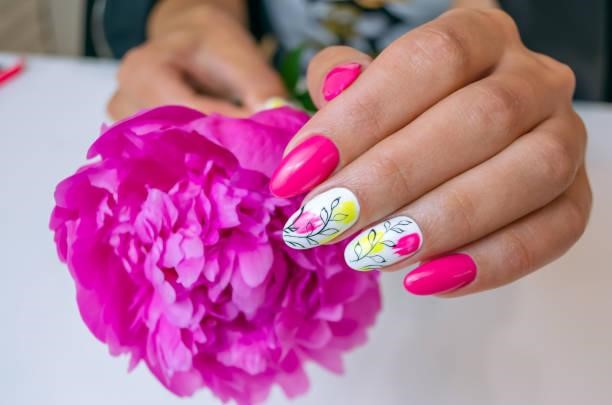 Beautiful women's hands with spring manicure nails with pink peony. Beautiful women's hands with spring manicure nails with pink peony. Spring Floral Nails stock pictures, royalty-free photos & images