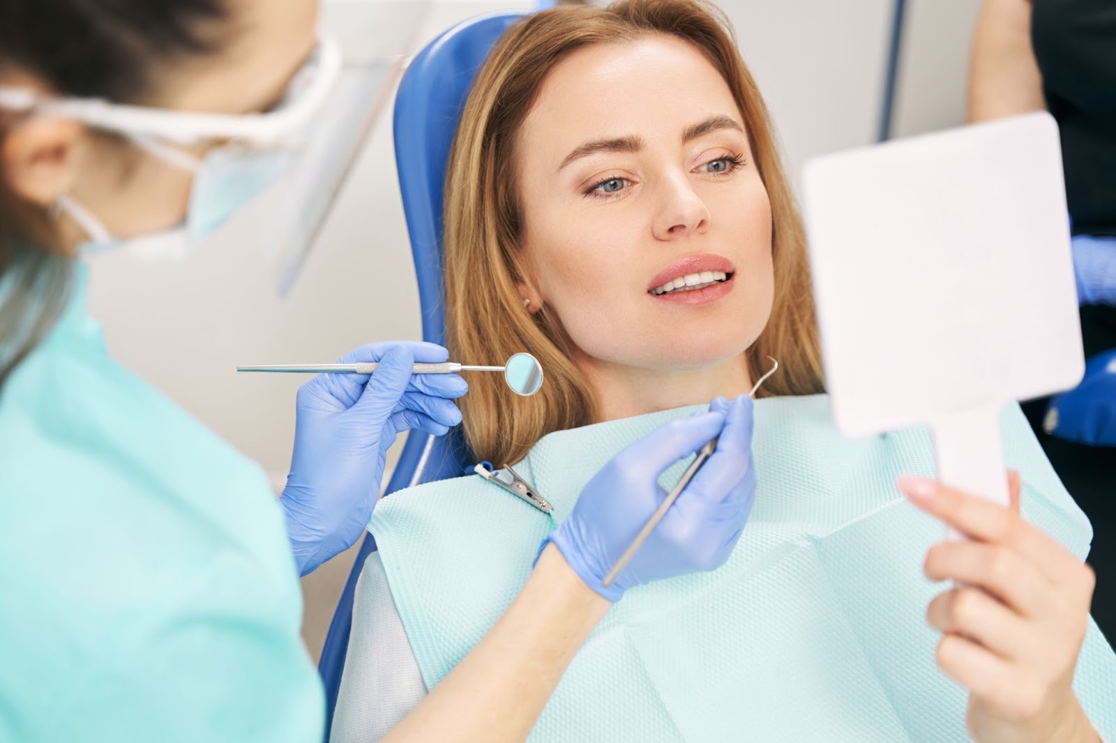 woman looking at a mirror during dental checkup