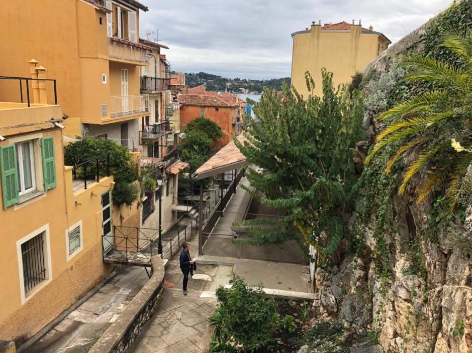 A person walking down a narrow street between buildings

Description automatically generated