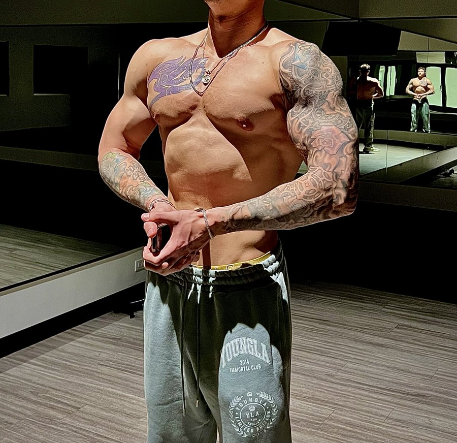 Jayden Marcos posing shirtless and showing off his chest and full sleeve tattoos in hot gym muscle selfie