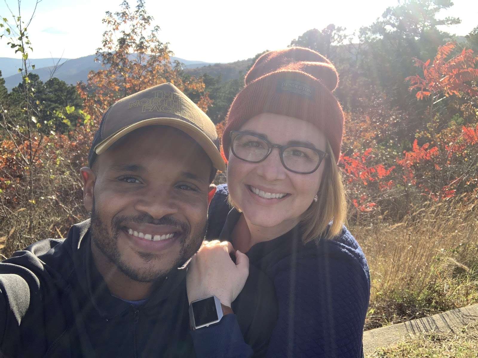 John and wife smiling for a photo while on an outdoor walk.