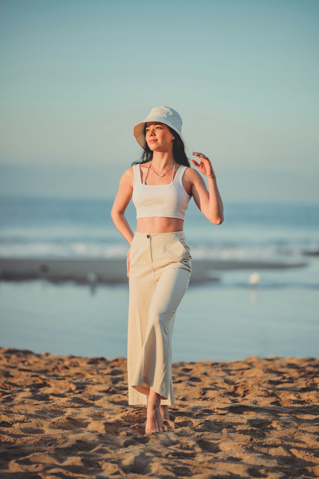 A woman with minimal accessories posing on a beach for a modelling headshot