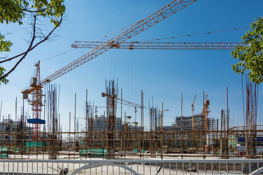  A construction site in progress with tall cranes and metal scaffolding