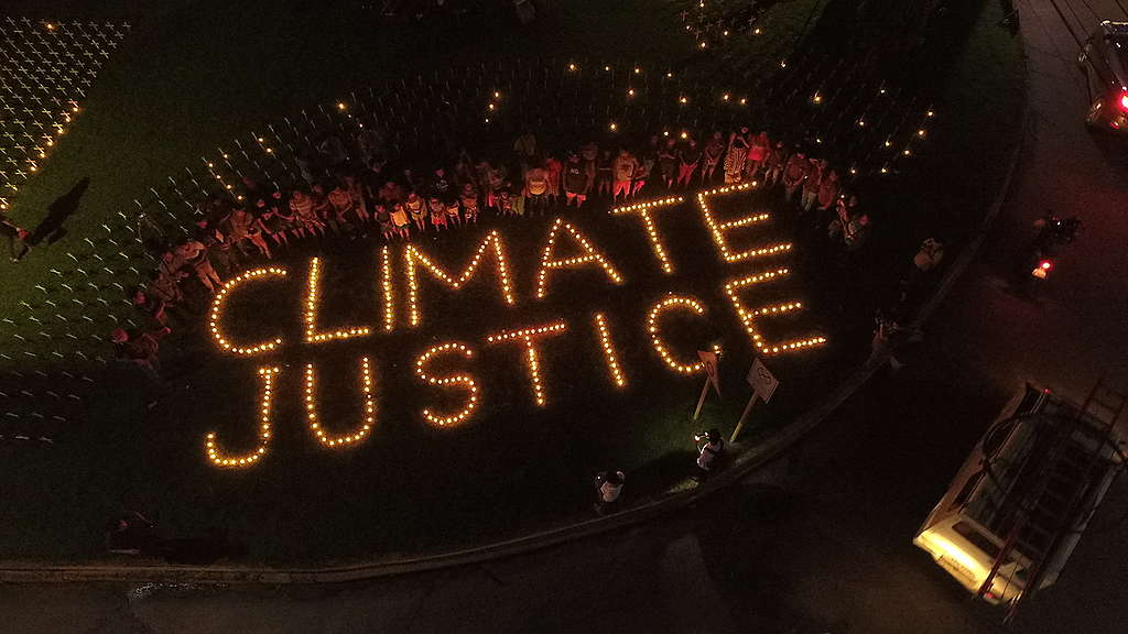 People light candles that spell out "Climate Justice”