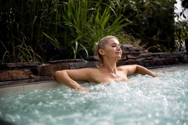 Free photo young woman relaxing in a jacuzzi