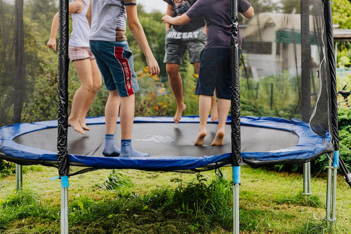 Children jumping on an outdoor trampoline