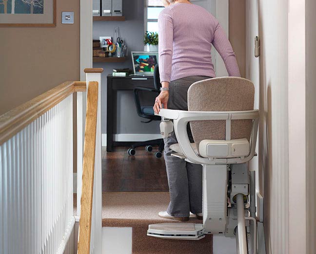 A lady getting off a Stannah stairlift