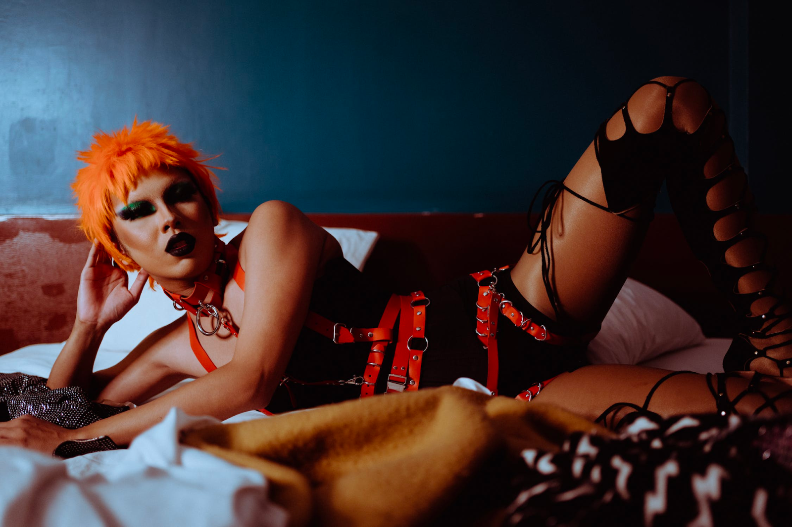 a woman in bed laying down with bondage straps