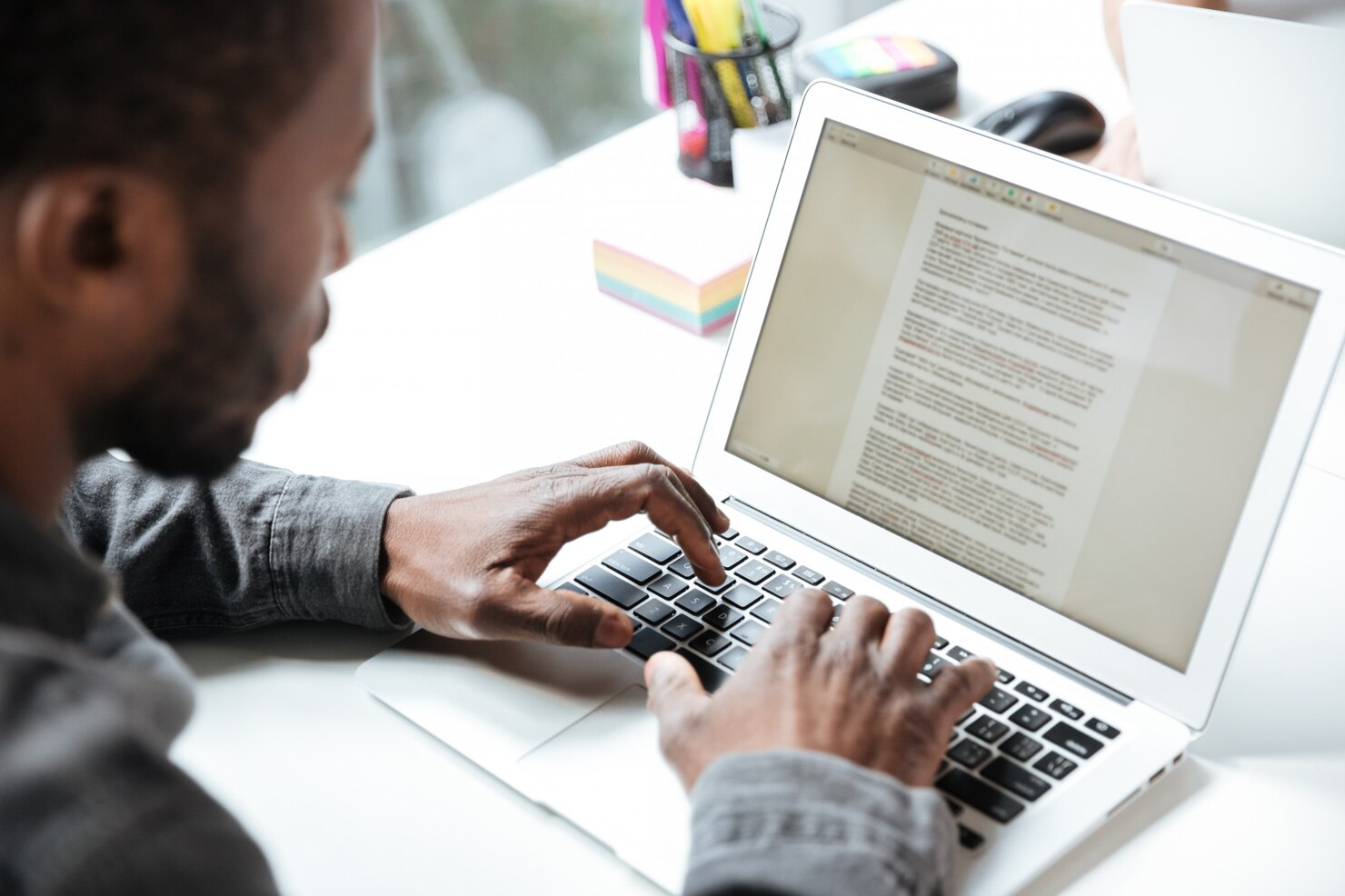 A man writing a blog on laptop.
