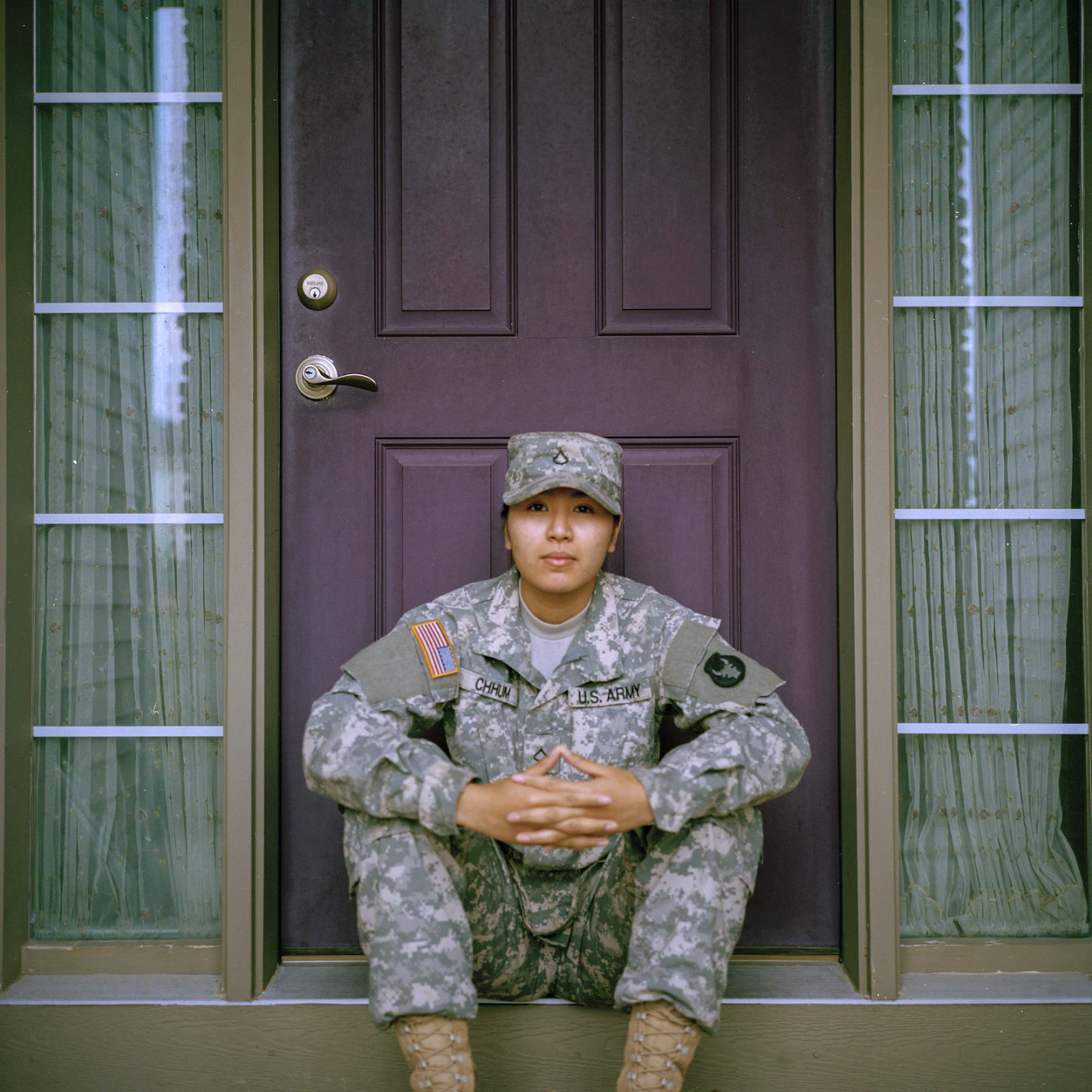 Woman in military uniform sitting in front of a closed door - Get To Know The United States' Five Military Academies