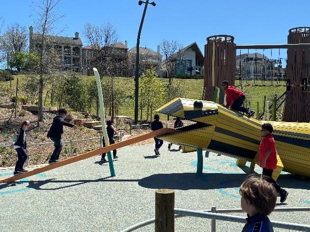 A group of kids playing on a playground

Description automatically generated
