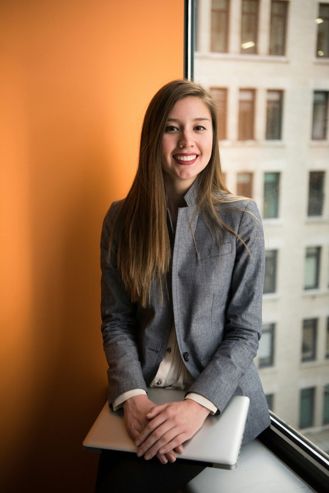 A female is posing with a warm smile and decent posture for her professional headshot