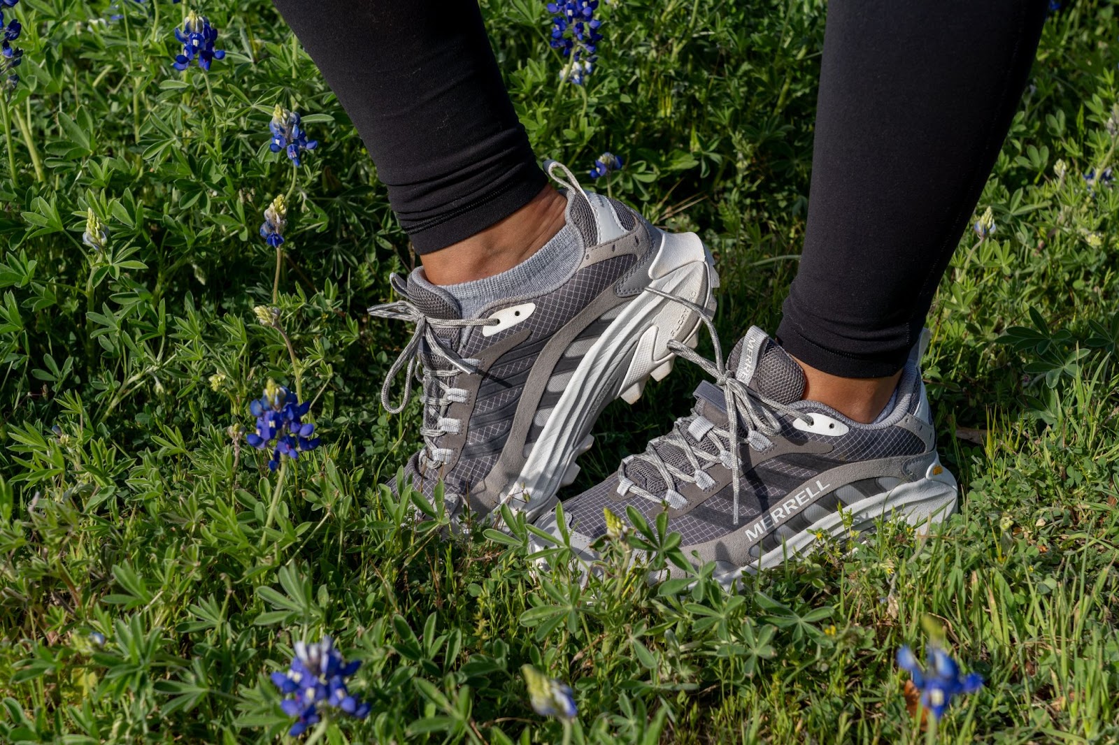 a person's feet in a field of flowers