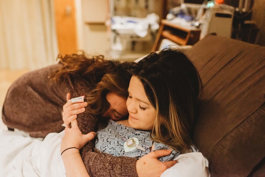 intended parent and gestational surrogate embracing in the hospital