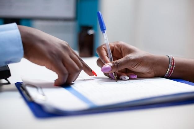 Doctor helping patient signing paperwork of medical insurance document form for illness healthcare treatment during clinical consultation in hospital. Policy bill of medication prescription, close-up