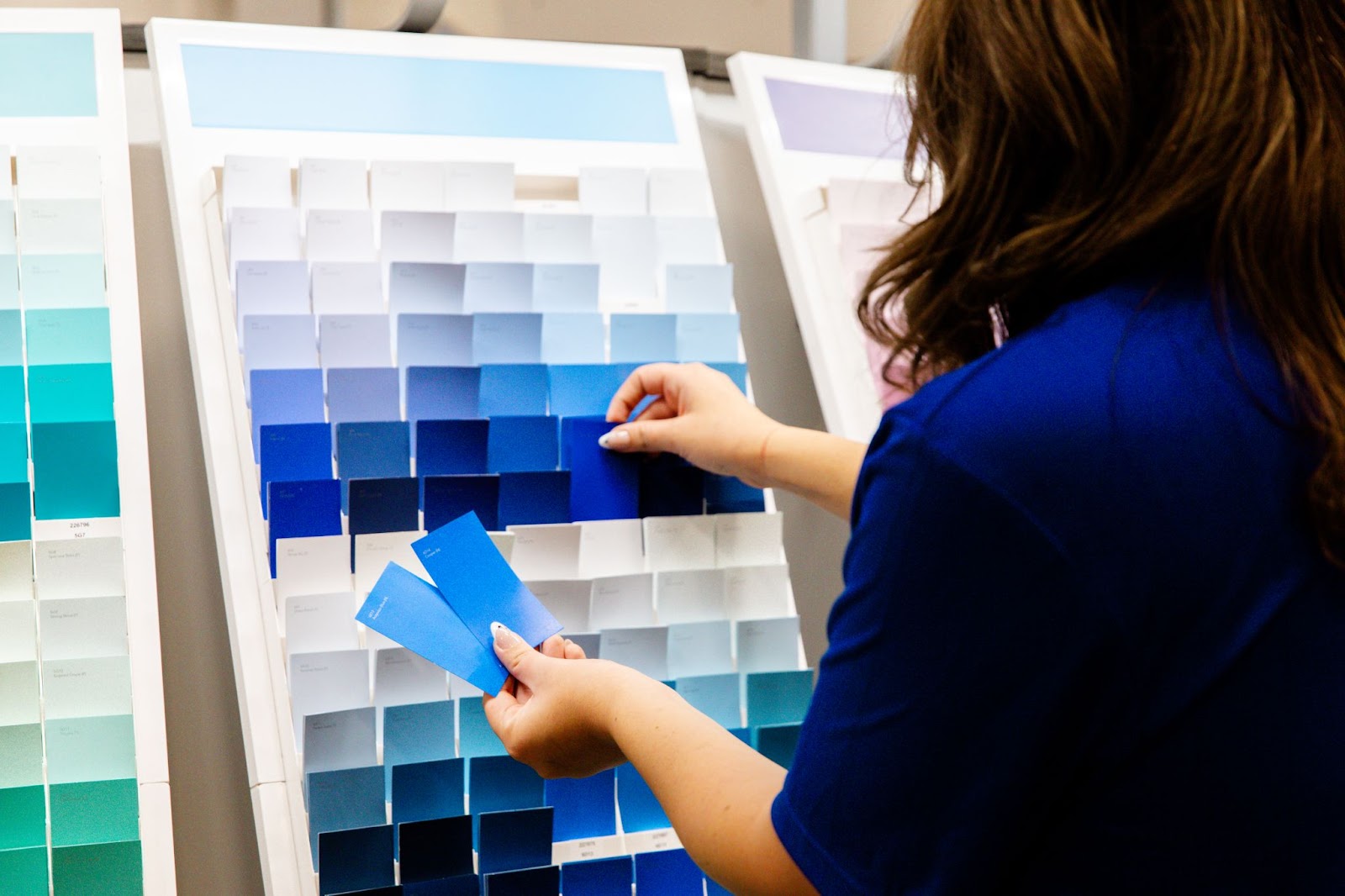 Woman Picking Out Blue Paint Swatches