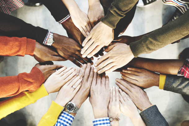 A group of hands together, showing a variety of people from different backgrounds and ethnic minorities.