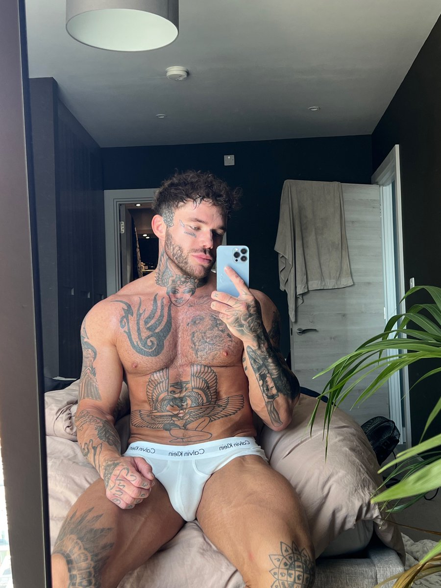 gay porn creator  Joel Hart posing on the bed in white calvin klein underwear taking an iphone mirror selfie