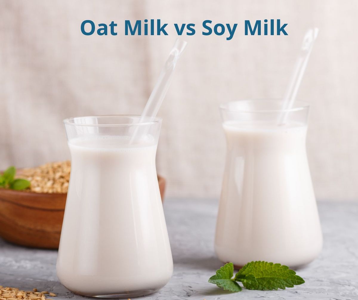 two cups of milk on a table with oat milk vs soy milk written on it.