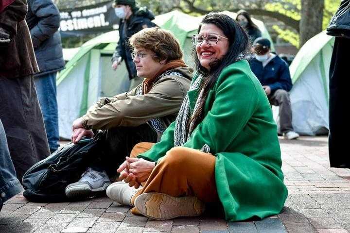 Rep. Tlaib smiles as she sits with protestors