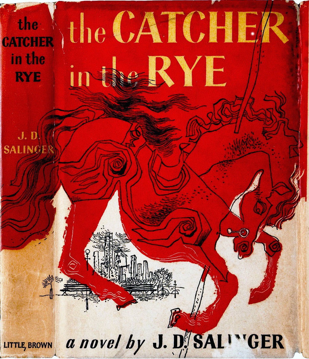 The first edition book jacket for The Catcher in the Rye. A large drawing of a horse, colored in red, in the foreground. In the background, the skyline of a city, with benches and trees visible. 