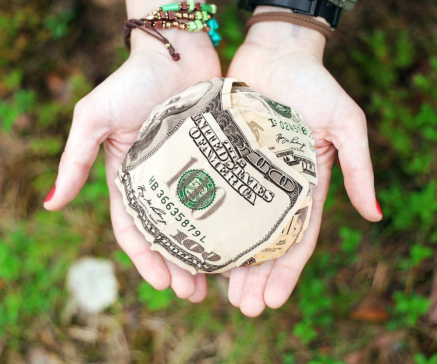 A woman holding a ball of cash