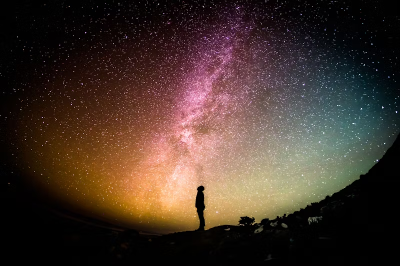 Human being silhouette looking up to the colorful nightsky