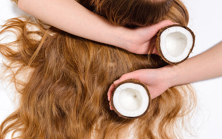 young girl hands natural hair and perfect skin with coconut in her hand