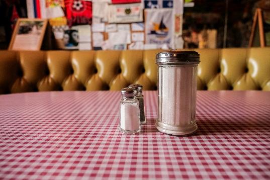 Sugar, salt, pepper shakers on check tablecloth