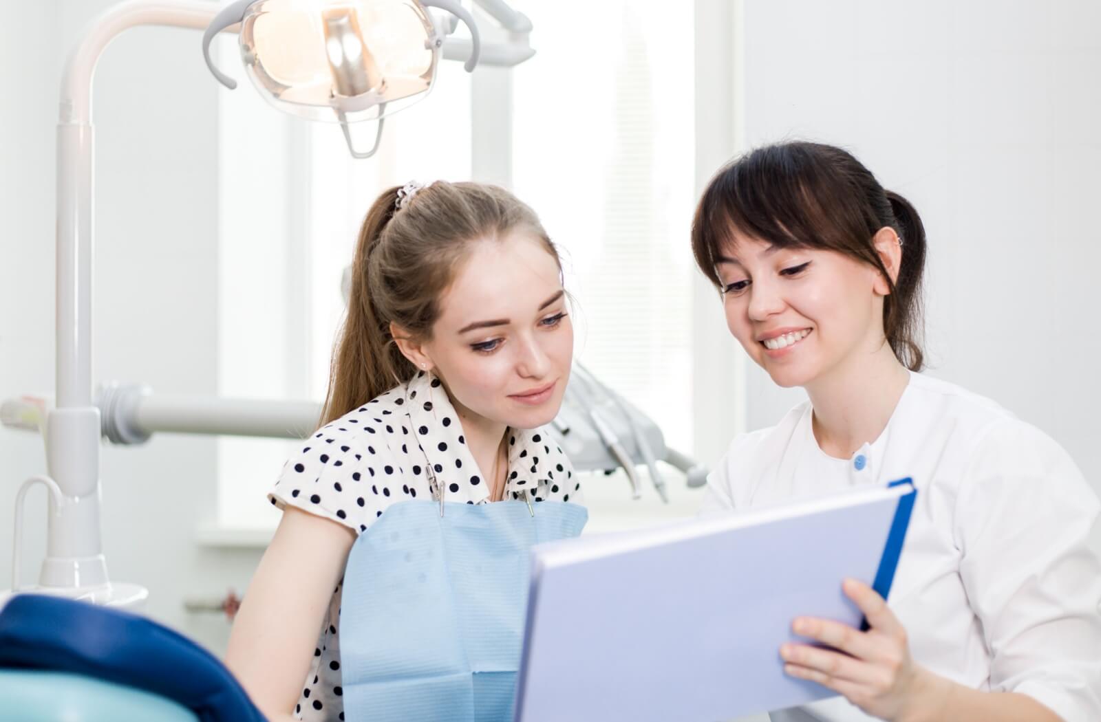 Young female patient talking to her dentist.