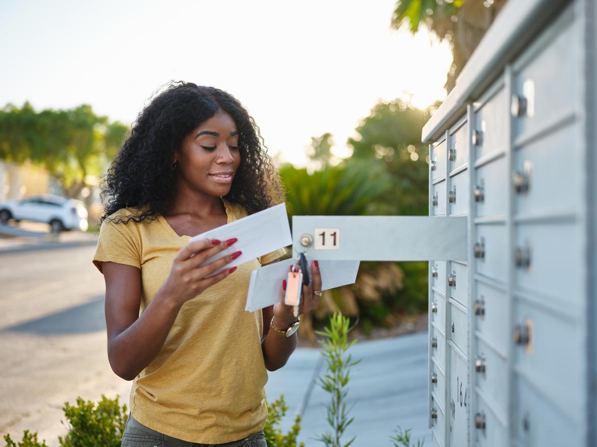 A person opening a mailboxDescription automatically generated