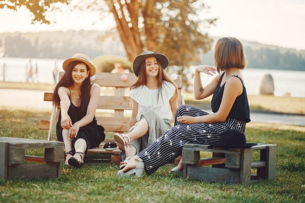 Three girls sitting in a park and discussing Galentine's captions for Instagram