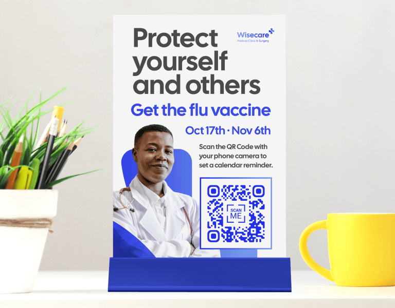 A blue and white table tent from a doctor’s office with a QR Code that invites patients to scan it and save their next flu shot date on a mobile device. 