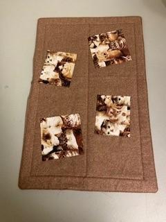 A brown cloth with pictures of dogs on it

Description automatically generated