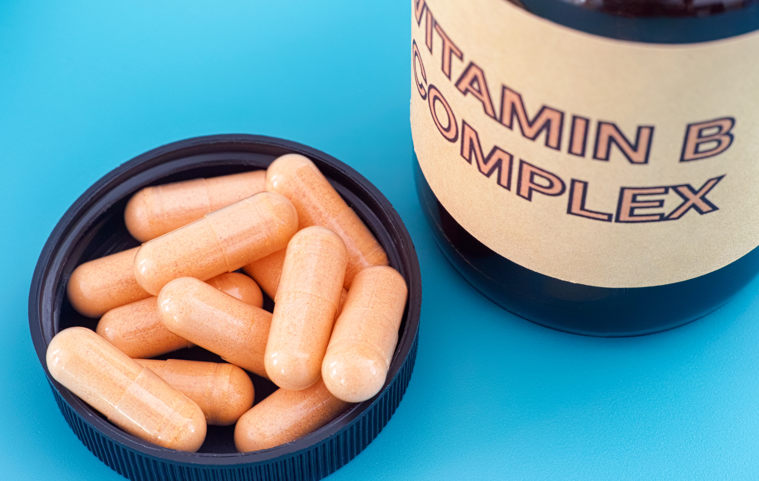 B vitamin complex capsules spilling out of a bottle.