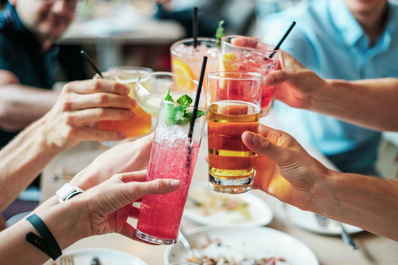 Group of people toasting with various cocktails at brunch.