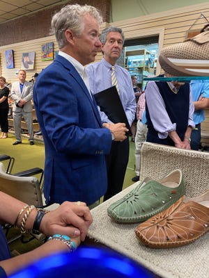 U.S. Sen. Rand Paul, left, recognizes Simon’s Shoes as his Senate Small Business of the Week during a visit on June 28 while current owner Bruce Simon looks on.
