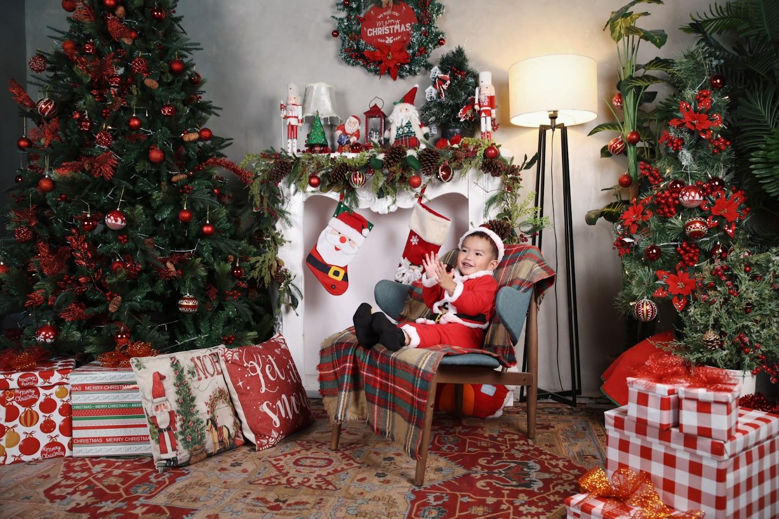 newborn christmas photo idea: baby seated by the fireplace wearing a Santa costume
