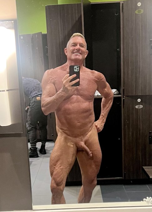 Matthew Figata taking an iphone mirror selfie and smiling naked at the gym
