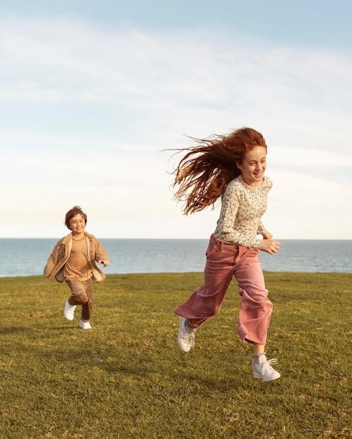 Foto gratuita niños de tiro completo corriendo al aire libre