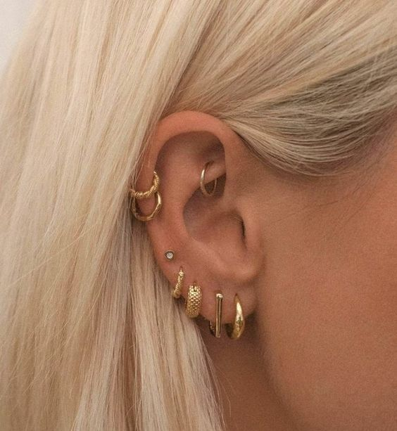 Side view of a girl wearing  multiple earrings on one ear