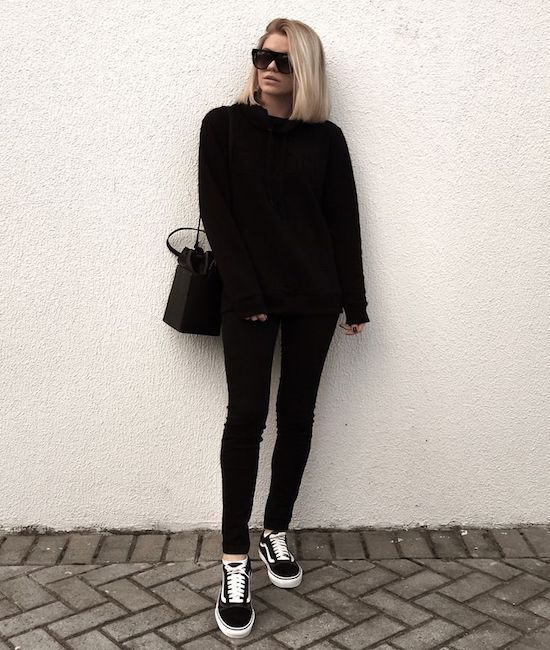 Picture showing a lady rocking an all black outfit  with the sneakers