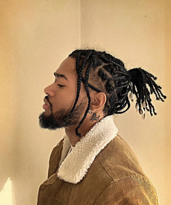 Hairstyles for Men: Picture of a man on braids with cowries