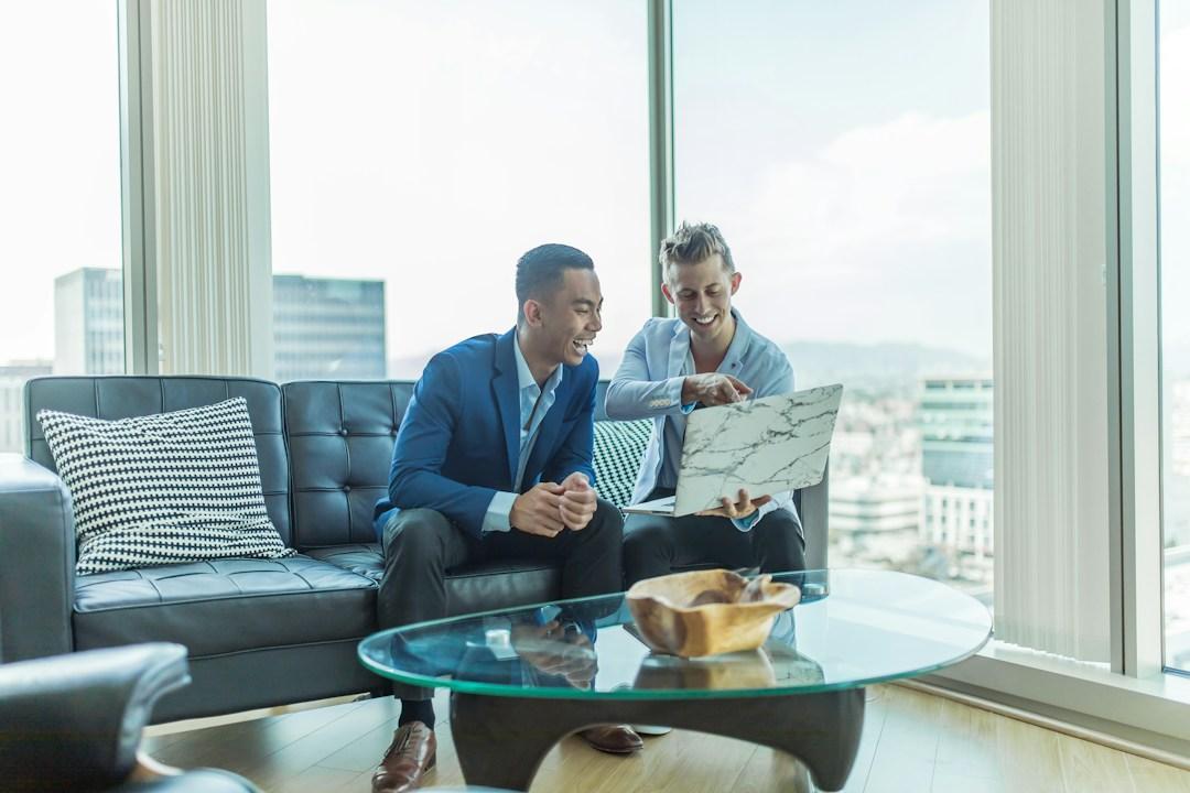 Businessmen discussing telecom expense management using a laptop