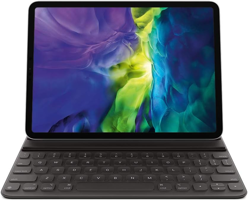 The Apple Magic Keyboard placed next to a MacBook on a white background, showing the seamless integration between devices.
